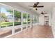 Enclosed sunroom with tile flooring, ceiling fans, and beautiful views of the landscaped yard at 10460 Silver Maple Ave, Oxford, FL 34484