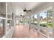 Enclosed sunroom with tile flooring, ceiling fans, and multiple windows providing natural light at 10460 Silver Maple Ave, Oxford, FL 34484