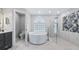 Stunning bathroom with a modern tub, glass-encased shower, and elegant marble tiling at 11024 Windchime Cir, Clermont, FL 34711