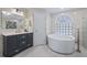 Bright bathroom featuring a soaking tub, glass shower, and vanity with modern fixtures at 11024 Windchime Cir, Clermont, FL 34711