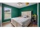 Inviting bedroom with bright green walls, wood-style flooring, and natural light at 11024 Windchime Cir, Clermont, FL 34711