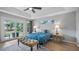 Well-lit bedroom featuring wood floors, a ceiling fan, and sliding door access to the backyard at 11024 Windchime Cir, Clermont, FL 34711