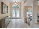Elegant foyer featuring decorative glass doors, tile flooring, and a mirrored accent piece at 11024 Windchime Cir, Clermont, FL 34711