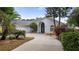 Inviting single-story home featuring a concrete driveway, arched entryway, attached garage, and mature landscaping at 11024 Windchime Cir, Clermont, FL 34711