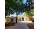Stunning single-story home with a curved driveway and arched entry, surrounded by lush greenery and mature trees at 11024 Windchime Cir, Clermont, FL 34711