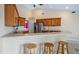 Open kitchen with bar seating, stainless appliances, and views into another bedroom at 11024 Windchime Cir, Clermont, FL 34711