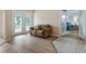 Bright living area with wood floors, cozy love seat, and glass doors leading to the outdoors at 11024 Windchime Cir, Clermont, FL 34711