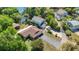 An aerial view shows the charming home with lakeside access and lush green landscaping surrounding the property at 12110 Palmetto Ct, Dunnellon, FL 34432