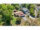 Aerial view of house with lush landscaping, private drive, lake access, and a detached covered structure at 12110 Palmetto Ct, Dunnellon, FL 34432