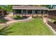 Expansive backyard featuring a charming sunroom, brick pathway, deck and lush greenery, perfect for outdoor enjoyment at 12110 Palmetto Ct, Dunnellon, FL 34432