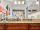 Bathroom featuring granite countertops, wood cabinets, decorated mirror, and walk-in shower at 12110 Palmetto Ct, Dunnellon, FL 34432