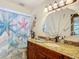 Bathroom featuring a granite countertop, shell mirror, and a starfish shower curtain at 12110 Palmetto Ct, Dunnellon, FL 34432