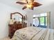 Bedroom featuring a leaf fan, palm tree bedding, and a wooden dresser at 12110 Palmetto Ct, Dunnellon, FL 34432