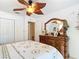 Bedroom featuring a leaf fan, palm tree bedding, and a wooden dresser at 12110 Palmetto Ct, Dunnellon, FL 34432