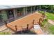 Spacious wooden deck with decorative chain railing, adjacent to sunroom, offers outdoor entertaining space at 12110 Palmetto Ct, Dunnellon, FL 34432