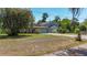 Charming home exterior featuring a well-maintained lawn, mature trees and long driveway at 12110 Palmetto Ct, Dunnellon, FL 34432