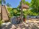 Outdoor area with brick patio, fire pit, wooden stairs, and lush landscaping at 12110 Palmetto Ct, Dunnellon, FL 34432