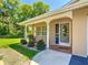 Inviting home exterior with a covered porch and landscaping, including a wooden rocking chair at 12110 Palmetto Ct, Dunnellon, FL 34432