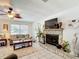 Open-concept living room with a stone fireplace, tile flooring, and large windows for natural light at 12110 Palmetto Ct, Dunnellon, FL 34432