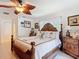 Bedroom featuring a queen bed with palm tree decor, light tile floors, and a leaf ceiling fan at 12110 Palmetto Ct, Dunnellon, FL 34432