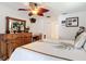 Bedroom with ceiling fan, dresser with mirror, palm tree decor, and tile floors at 12110 Palmetto Ct, Dunnellon, FL 34432