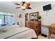Main bedroom with ceiling fan, wood furniture, with sliders to lanai and palm tree decor at 12110 Palmetto Ct, Dunnellon, FL 34432