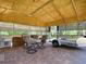Outdoor structure with dining set, grill, utility sink, and trailer on a brick patio with overhead insulation at 12110 Palmetto Ct, Dunnellon, FL 34432