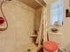 Shower featuring beige tiles, a built-in bench, and a shower curtain at 12110 Palmetto Ct, Dunnellon, FL 34432