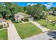 Aerial view of the home, showcasing the lawn, driveway and landscaping at 12346 Lake Valley Dr, Clermont, FL 34711