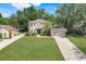 Stunning aerial view of a two-story home, spacious lawn, long driveway, and mature trees creating a serene setting at 12346 Lake Valley Dr, Clermont, FL 34711