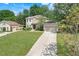 Traditional home exterior with a three-car garage, and lush front yard at 12346 Lake Valley Dr, Clermont, FL 34711