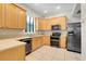 Charming kitchen with wood cabinets, modern appliances, and tile flooring at 12346 Lake Valley Dr, Clermont, FL 34711