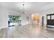 Open-concept living room with hardwood floors, leading to an outdoor patio through sliding glass doors and kitchen view at 12346 Lake Valley Dr, Clermont, FL 34711