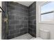 Modern bathroom featuring tiled shower with rainfall head and penny tile floor, plus toilet and window at 1415 S Baton Dr, Deltona, FL 32725