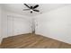 Bright bedroom features wood floors, ceiling fan, and a spacious closet with doors, providing ample storage at 1415 S Baton Dr, Deltona, FL 32725