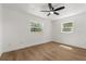 Bright bedroom with wood floors, two windows, and a ceiling fan at 1415 S Baton Dr, Deltona, FL 32725