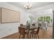 Bright dining area with modern chandelier, stylish table set, and neutral art, connecting seamlessly to the spacious living room at 1415 S Baton Dr, Deltona, FL 32725