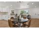 Stylish dining area showcasing a modern table, hardwood floors, and an open view to the kitchen at 1415 S Baton Dr, Deltona, FL 32725