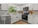 Modern kitchen featuring white cabinets, stainless steel appliances, and a beautiful tile backsplash at 1415 S Baton Dr, Deltona, FL 32725