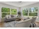 Bright living room with large windows offering picturesque views, stylish furnishings, and hardwood floors at 1415 S Baton Dr, Deltona, FL 32725
