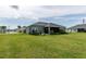 Spacious backyard with lush green grass and view of the home's exterior at 1422 Jeremy Cir, The Villages, FL 34762