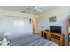Simple bedroom featuring closet storage, light colored walls, and a nearby TV at 1422 Jeremy Cir, The Villages, FL 34762