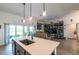 Open kitchen featuring an island with a sink and pendant lighting overlooking the living area at 1422 Jeremy Cir, The Villages, FL 34762