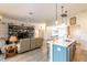 Open-concept living area with kitchen island, comfortable seating, and attractive decorative shelving at 1422 Jeremy Cir, The Villages, FL 34762