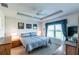 Cozy main bedroom with tray ceiling, ceiling fan, and large windows at 1422 Jeremy Cir, The Villages, FL 34762