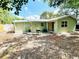 View of the backyard with a small patio area and lush, leafy trees at 14536 Sw 34Th Terrace Rd, Ocala, FL 34473