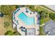 Aerial view of a beautiful community pool surrounded by lounge chairs, palm trees, and manicured landscaping at 15918 Summit Ct, Clermont, FL 34711