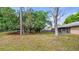 Home's shaded backyard featuring mature trees and a screened lanai at 15918 Summit Ct, Clermont, FL 34711