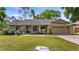 Charming single-story home featuring a well-maintained lawn and attached two car garage at 15918 Summit Ct, Clermont, FL 34711
