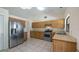 Spacious kitchen featuring stainless steel appliances, wooden cabinets and tile flooring at 15918 Summit Ct, Clermont, FL 34711